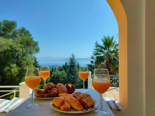 Villa Southern Comfort في ليفكيمي: طاولة مع طبق من الخبز وكؤوس من النبيذ