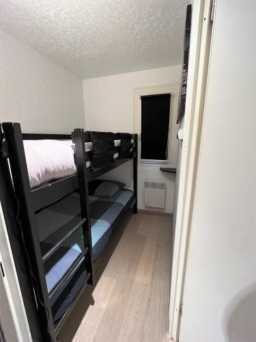 a small room with a bunk bed and a window at Location appartement saint lary 2/4 personnes in Saint-Lary-Soulan