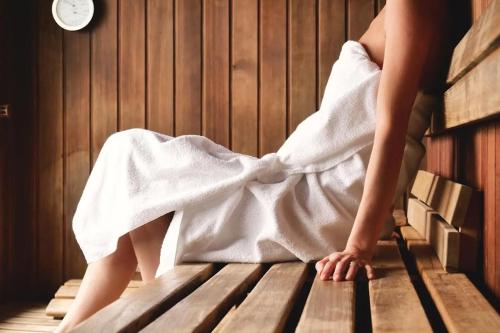 a woman sitting in a bath tub with a towel at La Viste - SPA-JACUZZI - MASSAGE- SAUNA - 4 SAISONS - Piscine Chauffée Toute l'année - Heated POOL - 800m City Centre in Nyons