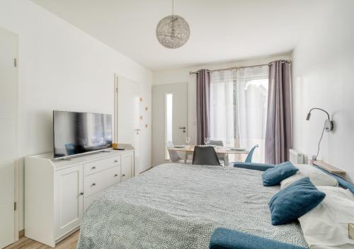 Schlafzimmer mit einem Bett, einem TV und einem Tisch in der Unterkunft L'ESCAPADE entre DISNEY et PARIS in Noisy-le-Grand