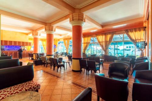 a restaurant with chairs and tables and windows at Hotel Bellerive in Casablanca
