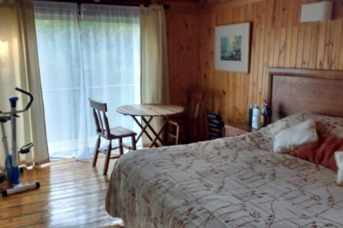 1 dormitorio con cama, mesa y ventana en Hermosa casa en Lago Vichuquén, en Lago Vichuquen