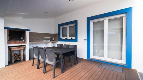 a dining room with a black table and chairs at Quinta Rico - House II in Praia da Vitória