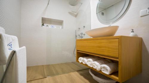 a bathroom with a sink and a vanity with towels at Quinta Rico - House II in Praia da Vitória