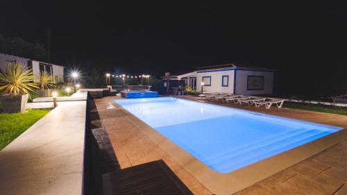 a large swimming pool in a yard at night at Quinta Rico - House II in Praia da Vitória
