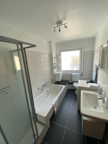 a bathroom with a tub and a toilet and a sink at Offenbach Center Residenz in Offenbach