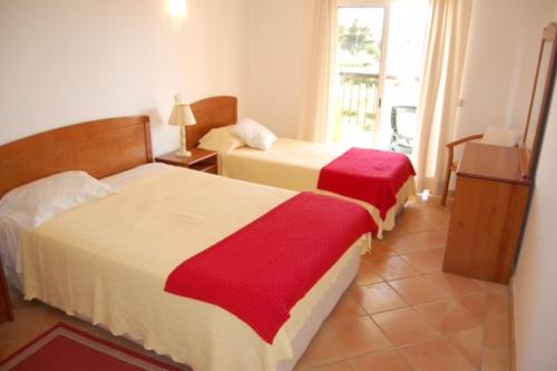 a hotel room with two beds and a window at Clube Alvor Ria in Alvor