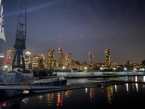 a city skyline at night with a river and a crane at LUXURY Home SPA Villa Sauna Jacuzzi EXCEL CANARY WHARF ZONE 2 in London