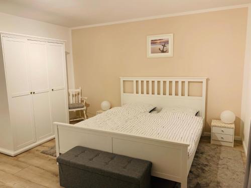 a bedroom with a white bed and a white cabinet at Altstadt Ankerplatz in Emden