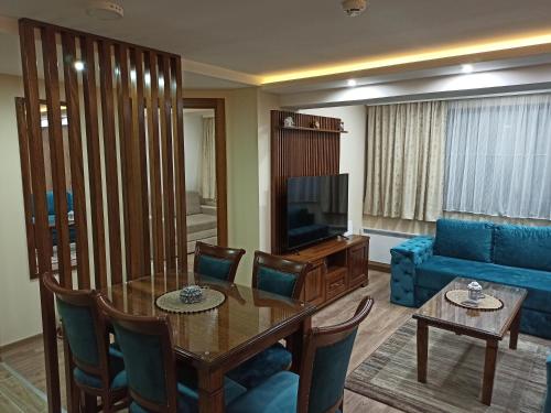 a living room with a table and a blue couch at Jasmin President Kop in Kopaonik