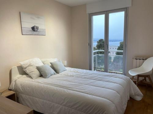 ein weißes Schlafzimmer mit einem großen Bett und einem Fenster in der Unterkunft Sète, grande villa familiale avec Jacuzzi in Sète