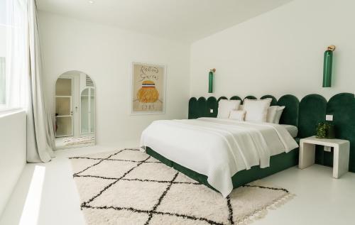 a bedroom with a large bed with a green headboard at The Cali Villas Canggu in Canggu