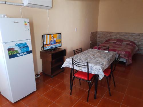 a dining room with a table and a refrigerator at El Palacio in La Punta