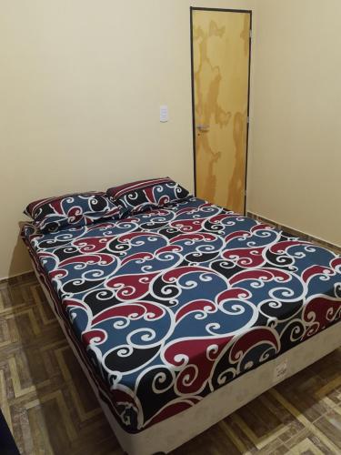 Una cama en un dormitorio con una manta de colores. en El Palacio en La Punta