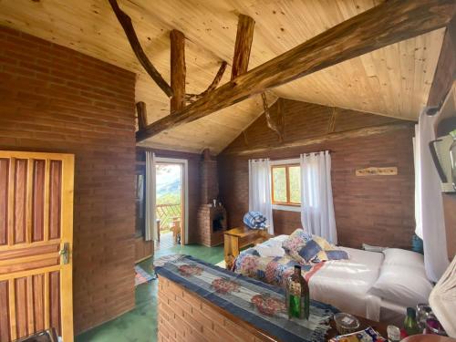 ein Wohnzimmer mit einem Bett und einer Holzdecke in der Unterkunft RECANTO DO LEÃO in Aiuruoca