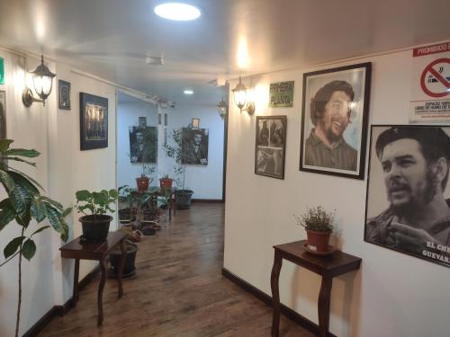 a room with pictures on the walls and potted plants at Hotel el Che No apto para corruptos in Azogues