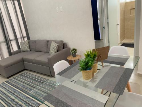 sala de estar con sofá y mesa de cristal en el Departamento 2 habitaciones con vista a la piscina by EITA, en Cancún
