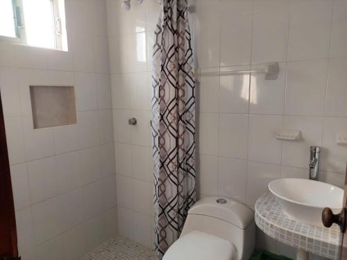 a bathroom with a toilet and a sink at Posada Casa Bugambilias in Tecolutla