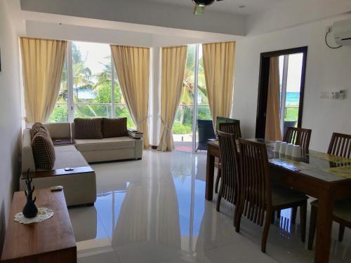 a living room with a couch and a table and chairs at Nilaveli Ocean Condos in Trincomalee