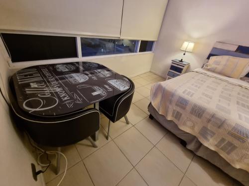 a bedroom with a table and a bed and a window at CENTRAL VISTA ECUADOR 2 in Santiago