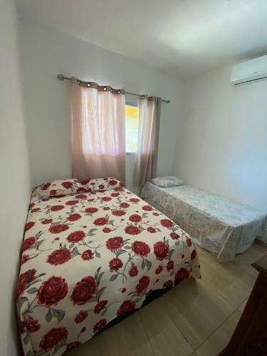 a bedroom with a bed with a floral bedspread at Casa De Praia em Itamaracá in Itamaracá