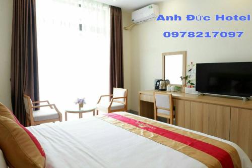 a hotel room with a bed and a flat screen tv at Anh Duc Hotel in Tam Ðảo