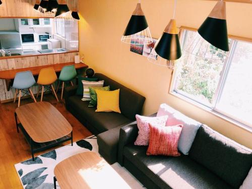 ein Wohnzimmer mit Sofa und Tisch in der Unterkunft 恩納村名嘉真フォレストヴィラ12時チェックアウト可ダブルベッド2台と2段ベッドとユニットバス2室 in Onna