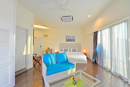 a bedroom with a bed and a blue couch at Ramada by Wyndham Langkawi Marina in Kuah