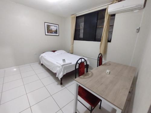 Habitación pequeña con cama y mesa en Departamento Melly, en Tarapoto