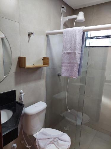 a bathroom with a shower with a toilet and a sink at Flat Casa da Praia in Porto De Galinhas