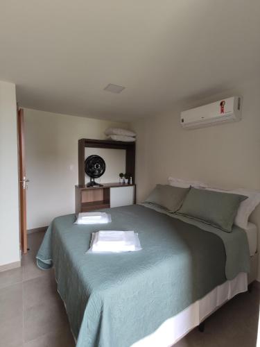 a bedroom with a large bed with a blue blanket at Apto climatizado à beira-mar c/ piscina-Intermares in Cabedelo