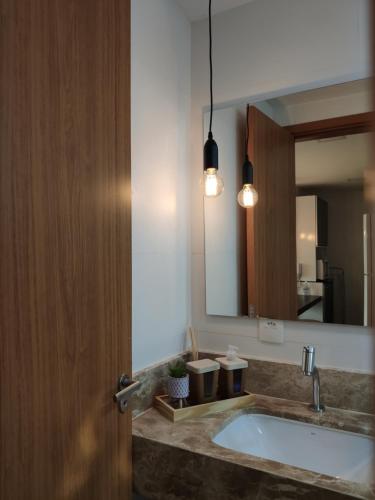 a bathroom with a sink and a mirror at Apto climatizado à beira-mar c/ piscina-Intermares in Cabedelo