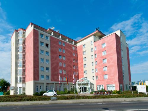 ein rot-weißes Gebäude an der Straßenseite in der Unterkunft ACHAT Hotel Schwarzheide Lausitz in Schwarzheide