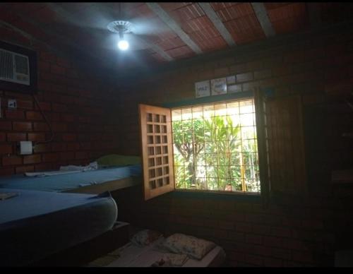 a room with a window and a brick wall at Prive das Acacias in Porto De Galinhas