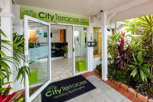 una entrada a un edificio de terrazas con plantas en City Terraces Cairns en Cairns