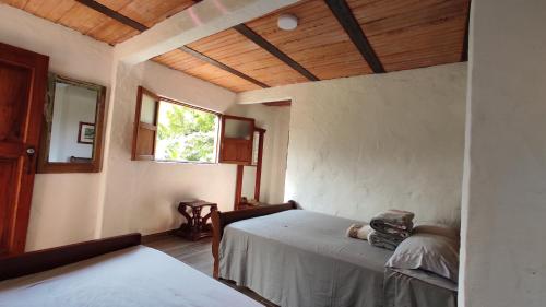 a bedroom with two beds and a window at Casa La Martina disponible en Jardín Antioquia in Jardin