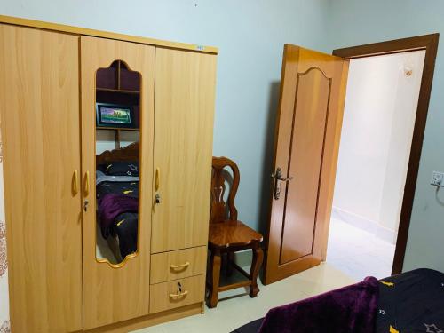 a cabinet with a mirror and a chair in a room at Sweet Home in Phnom Penh