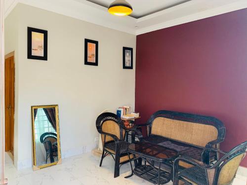 a living room with a bench and a purple wall at Sweet Home in Phnom Penh