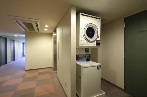 a washer and dryer in a hallway in a building at Smile Hotel Takaoka Ekimae in Takaoka
