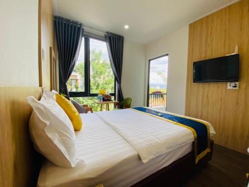 a bedroom with a large bed with a flat screen tv at VISION HOTEL in Phan Rang