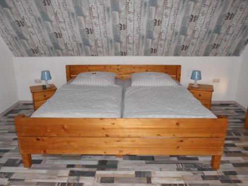 a bedroom with a wooden bed with two night stands at Möwennest in Neuharlingersiel