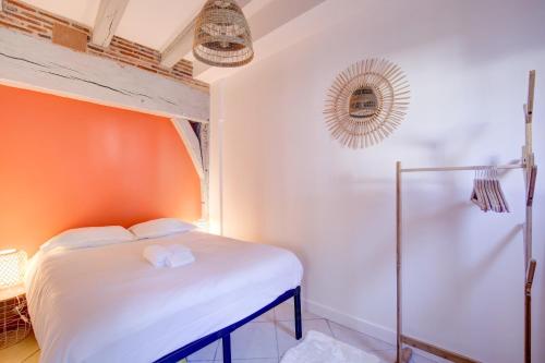 Ce lit se trouve dans un dortoir doté d'un mur orange. dans l'établissement Le Chambord Beautiful half-timbered house with terrace, à Tours