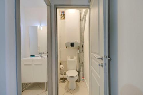une salle de bain blanche avec des toilettes et un lavabo dans l'établissement Le Chambord Beautiful half-timbered house with terrace, à Tours