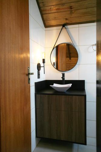 a bathroom with a sink and a mirror at Cabanas Charme da Serra in Cambará