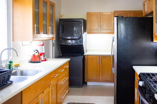 a kitchen with a black refrigerator and a sink at A home away from home in Richmond