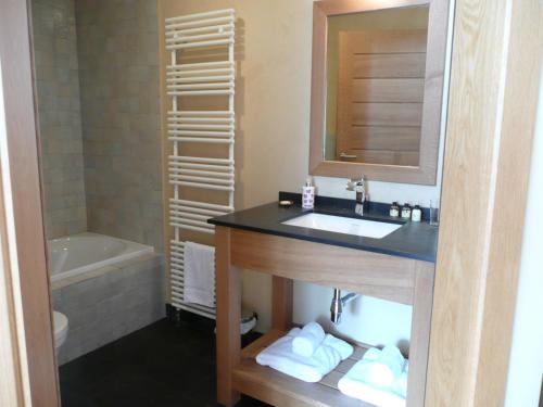 y baño con lavabo, espejo y bañera. en Chambre d'hôtes La Forestière, en Le Hohwald