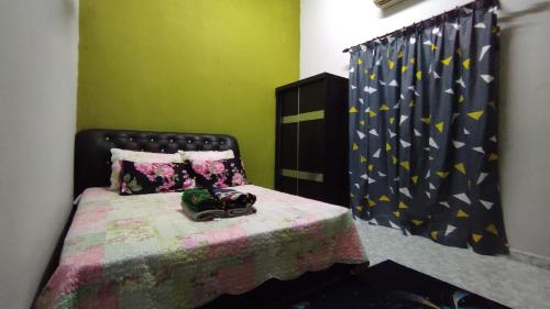 a bedroom with a bed with a black headboard at Homestay Opah Parit Buntar, Perak in Parit Buntar