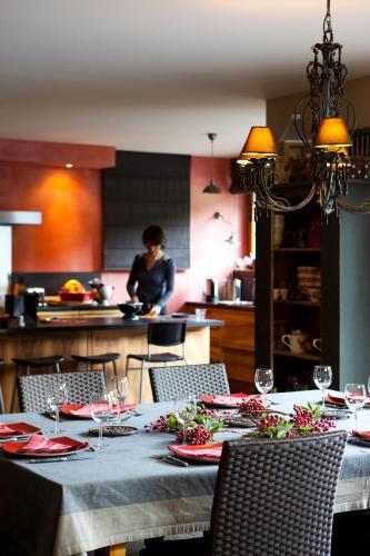 - une table avec des verres à vin et une femme dans la cuisine dans l'établissement Chambre d'hôtes La Forestière, au Hohwald