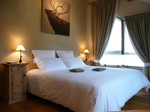 - une chambre dotée d'un lit blanc avec deux chapeaux dans l'établissement Chambre d'hôtes La Forestière, au Hohwald