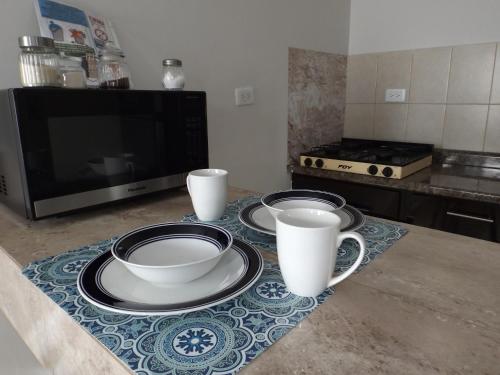 a kitchen with two cups and plates on a counter at Departamento privado zona de la UACH in Chihuahua
